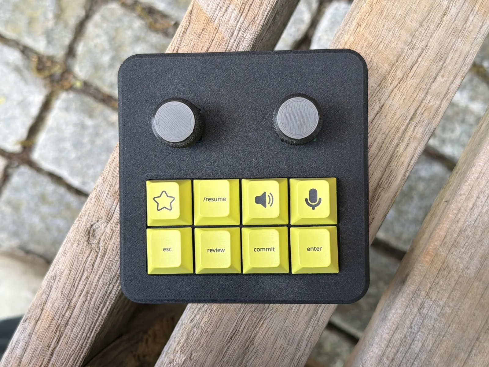 Vibecoding keyboard: black macropad with two knobs and yellow keys labeled esc, review, commit, enter, /resume, mic, and speaker